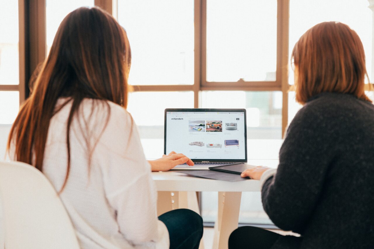 Two woman are discussing the difference between staff recruitment and outsourcing staff.